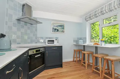 a kitchen with black cabinets and a counter top at 2 Porthilly Cottages in Wadebridge