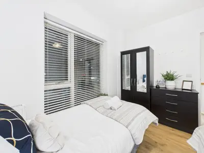 a bedroom with two beds and a large window at Harveys Yard by Signature Stays - Luxury home - Beach - Parking in Hayle