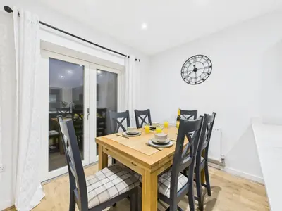 a dining room with a wooden table and chairs at Harveys Yard by Signature Stays - Luxury home - Beach - Parking in Hayle