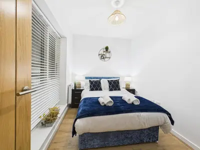 a bedroom with a bed with blue and white sheets at Harveys Yard by Signature Stays - Luxury home - Beach - Parking in Hayle