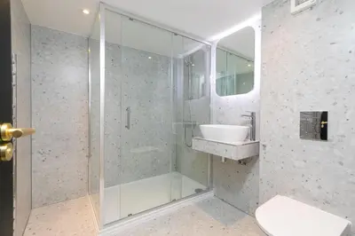 a bathroom with a glass shower and a sink at White Mist Cottage in St Ives