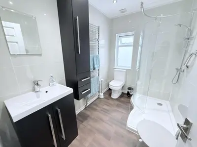 a bathroom with a sink and a shower and a toilet at Meadow View - Widemouth Bay Cornwall in Widemouth Bay