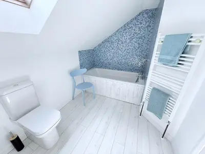 a bathroom with a toilet and a bath tub at Meadow View - Widemouth Bay Cornwall in Widemouth Bay