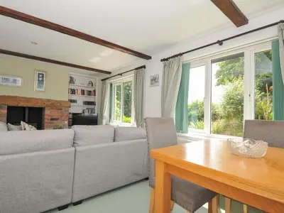 a living room with a couch and a table at Upper Court Cottage in Bude
