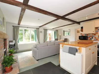 a living room with a couch and a table at Upper Court Cottage in Bude