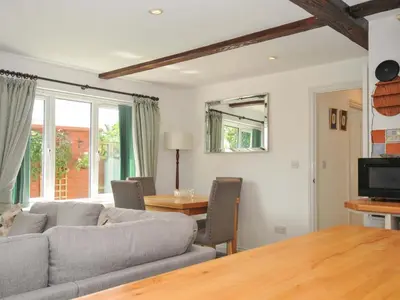 a living room with a couch and a table at Upper Court Cottage in Bude