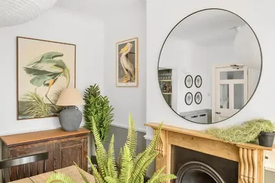a living room with a mirror over a fireplace at Palm House in Newquay