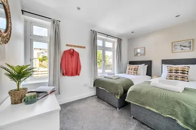 a bedroom with two beds and a window at Palm House in Newquay