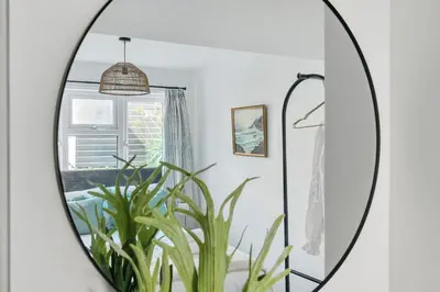 a mirror in a room with a plant at Palm House in Newquay