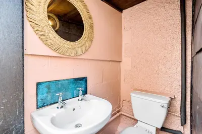 a bathroom with a sink and a mirror at Palm House in Newquay