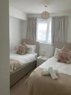 a bedroom with two beds and a window at 45 st Nicholas Court in St Ives