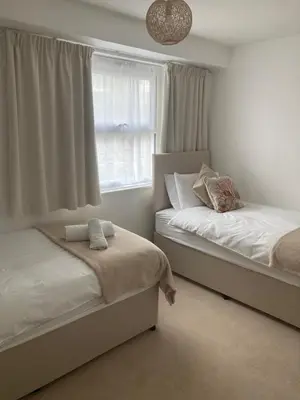a bedroom with two beds and a window at 45 st Nicholas Court in St Ives