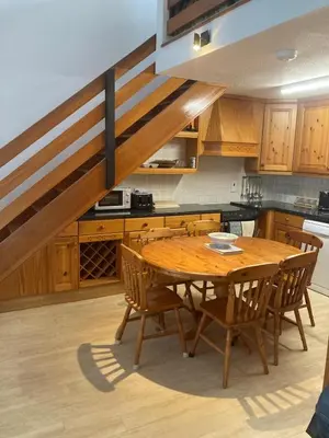 a kitchen with a wooden table and wooden chairs at 45 st Nicholas Court in St Ives