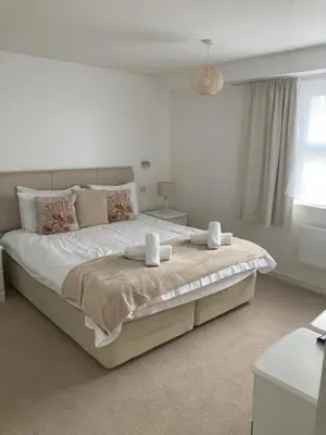 a bedroom with a large bed with two towels on it at 45 st Nicholas Court in St Ives