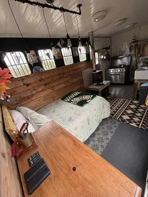 a bedroom with a bed and a table in a room at Miss Francis Horse Wagon in Looe