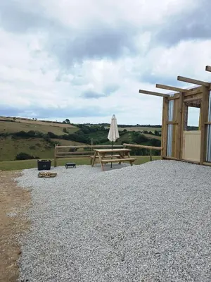 a patio with a picnic table and an umbrella at Miss Francis Horse Wagon in Looe