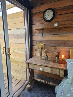 a room with a table with a clock on the wall at Miss Francis Horse Wagon in Looe