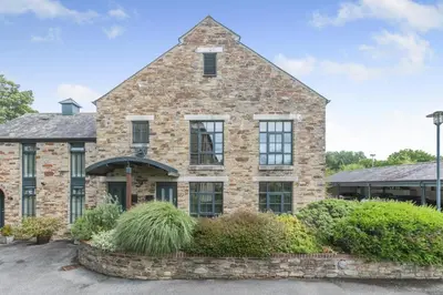 an old brick house with windows and bushes at 1 Bed in Lostwithiel oc-n32748 in Lostwithiel