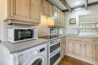 a kitchen with a washing machine and a microwave at 2 Bed in Liskeard oc-t32876 in Duloe