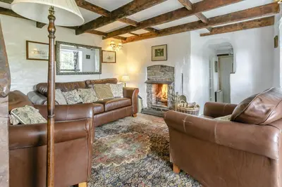 a living room with leather furniture and a fireplace at 2 Bed in Liskeard oc-t32876 in Duloe