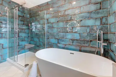 a bath tub in a bathroom with blue tiles at 4 Bed in Padstow oc-r32776 in Padstow