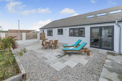 a patio with a table and chairs and a house at 4 Bed in Padstow oc-r32776 in Padstow