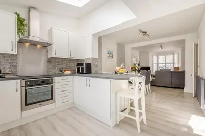 a kitchen with white cabinets and a table and chairs at 3 Bed in Padstow oc-g32860 in Padstow