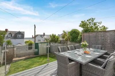 a patio with a table and chairs on a deck at 3 Bed in Padstow oc-g32860 in Padstow