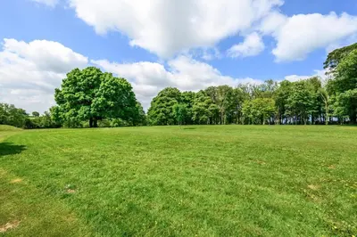a large green field with trees in the background at 2 Bed in St. Tudy oc-m32233 in Saint Tudy