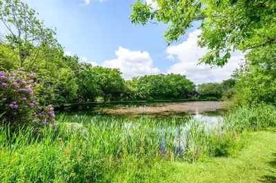 a pond in a park with trees and flowers at 2 Bed in St. Tudy oc-m32233 in Saint Tudy