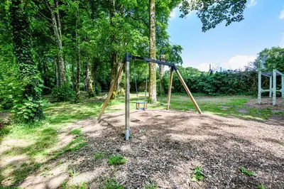 an empty swing set in a park with trees at 2 Bed in St. Tudy oc-m32233 in Saint Tudy