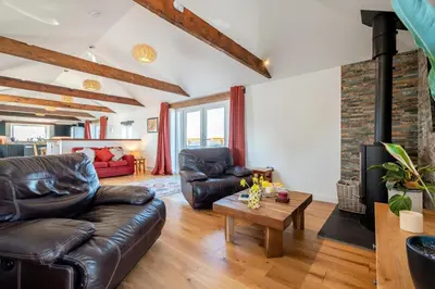 a living room with a leather couch and a fireplace at 3 Bed in St. Mawgan oc-h30677 in Saint Eval