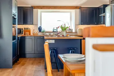 a kitchen with blue cabinets and a table and a window at 3 Bed in St. Mawgan oc-h30677 in Saint Eval