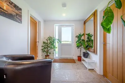 a living room with a leather couch and potted plants at 3 Bed in St. Mawgan oc-h30677 in Saint Eval