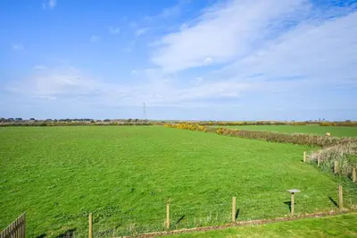 a large field of green grass with a fence at 3 Bed in St. Mawgan oc-h30677 in Saint Eval