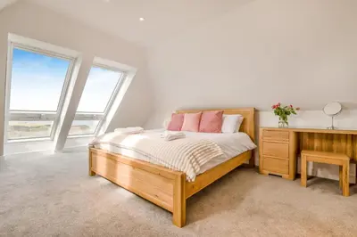 a bedroom with a bed and a desk and windows at 3 Bed in Tintagel oc-e32938 in Tintagel