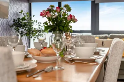 a dining table with a vase of flowers on it at 3 Bed in Tintagel oc-e32938 in Tintagel
