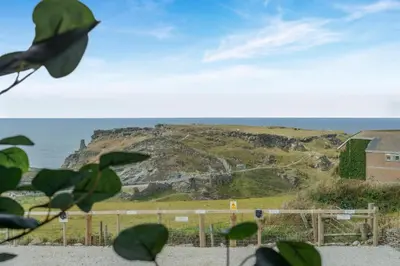 a view of a hill with a house and the ocean at 3 Bed in Tintagel oc-e32938 in Tintagel
