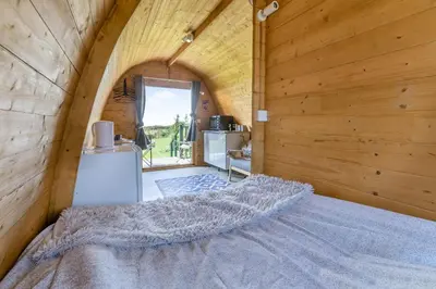 a large bed in a room with wooden walls at 1 Bed in Four Lanes oc-s32768 in Carnbrea