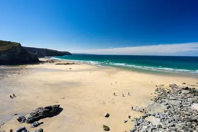 a group of people walking on a beach at 1 Bed in Four Lanes oc-s32768 in Carnbrea