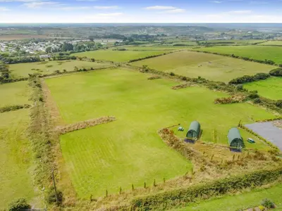 an aerial view of a large field with two tents at 1 Bed in Four Lanes oc-s32768 in Carnbrea