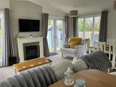 a living room with a couch and a fireplace at Lodge in St Merryn in St Merryn