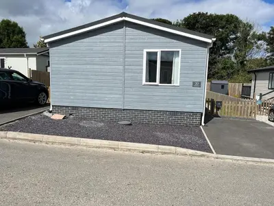 a small blue house with a window in a driveway at Lodge in St Merryn in St Merryn
