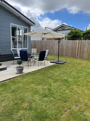a patio with a table and chairs and an umbrella at Lodge in St Merryn in St Merryn