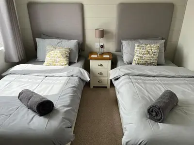 a bedroom with two beds and a night stand at Lodge in St Merryn in St Merryn