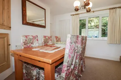 a dining room with a wooden table and chairs at Kiln Cottage in Fowey