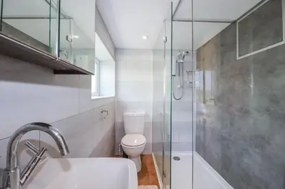 a bathroom with a shower and a toilet and a sink at Kiln Cottage in Fowey