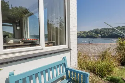 a blue bench sitting in front of a window at Kiln Cottage in Fowey