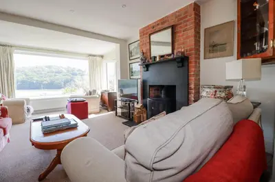 a living room with a couch and a fireplace at Kiln Cottage in Fowey