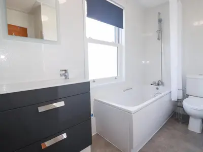 a bathroom with a tub and a toilet and a sink at Tregundy Farmhouse in Perranporth